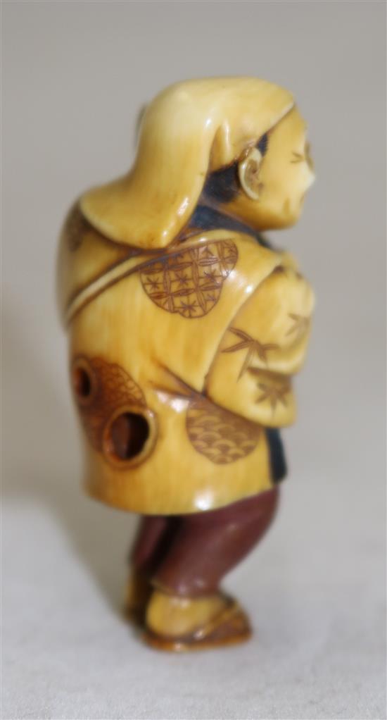 A Japanese tinted ivory figure of a street vendor, Taisho period, 5cm